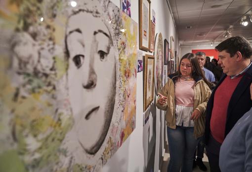 Asistentes a la inauguración contemplan alguna de las obras