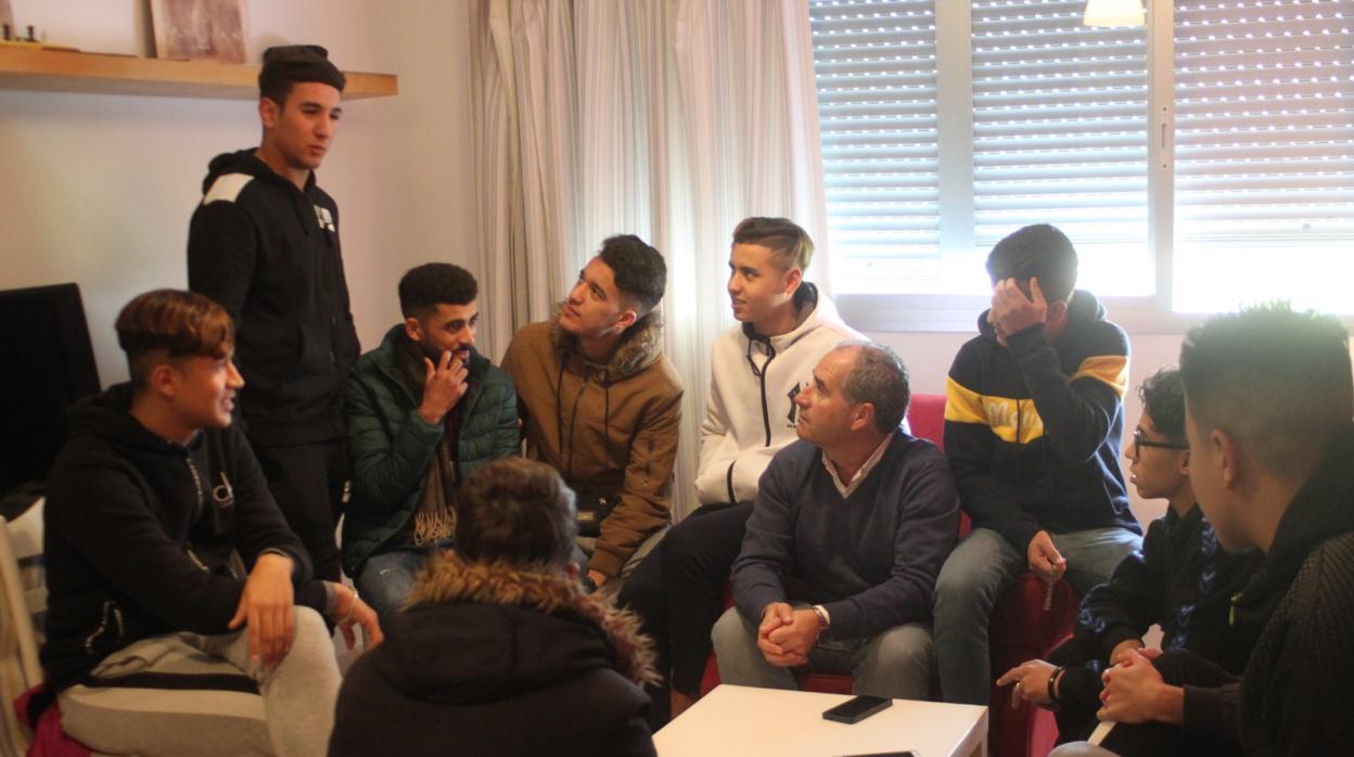 Un grupo de jóvenes con un representante de la ONG en un piso de acogida