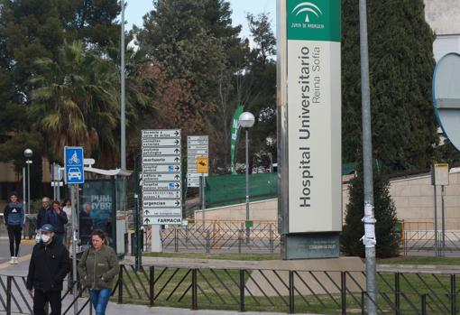 Una hombre con mascarilla cruza hacia el aparcamiento del Reina Sofía