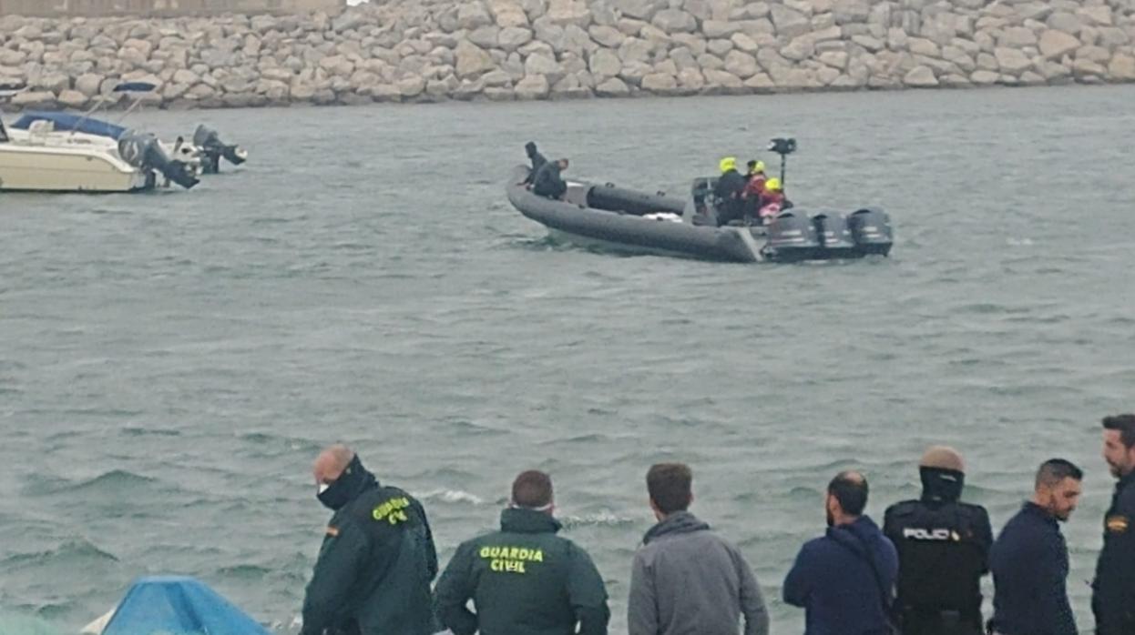 Imagen de los agentes y de la narcolancha ya en en el interior del puerto de La Atunara