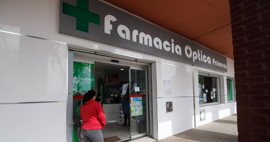 Una mujer espera su turno en la farmacia de Las Palmeras