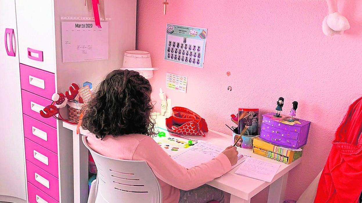 La pequeña de la casa reaiza las tareas en su habitación