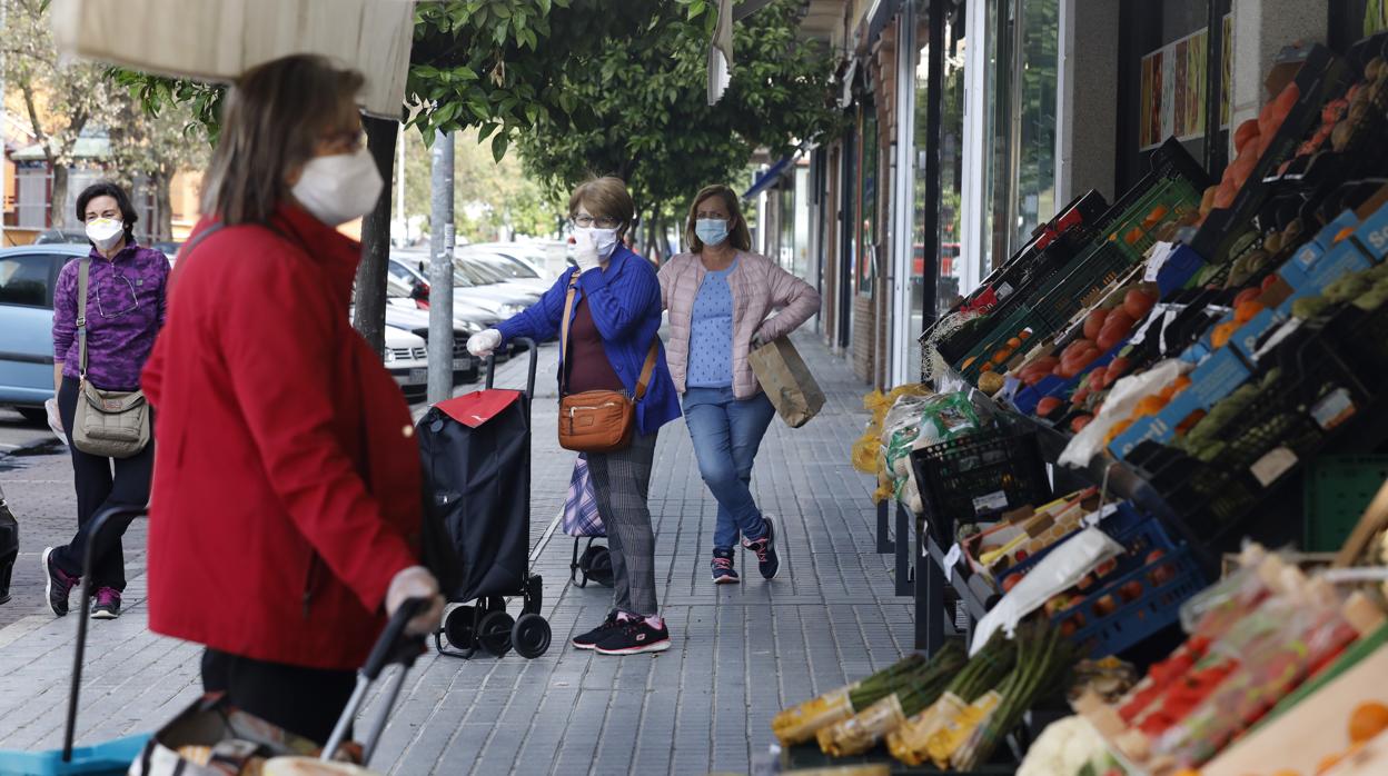 Mujeres hacen cola frente a una tienda de fruta en el barrio de Poniente de Córdoba