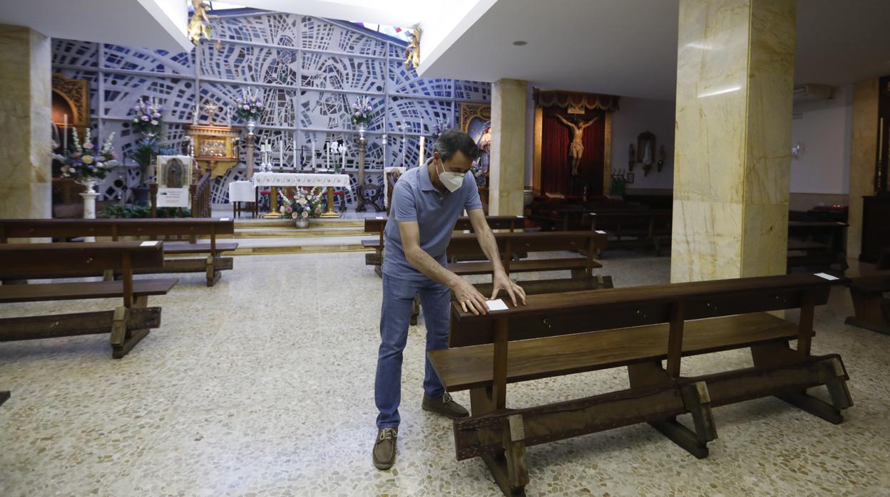 Un hombre prepara los bancos en la parroquía de Santa Teresa, en Ciudad Jardín