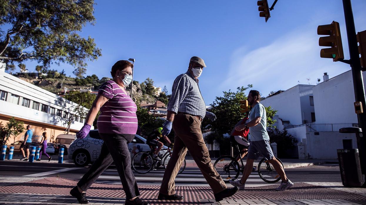 Unos viandantes con mascarillas paseando por Málaga