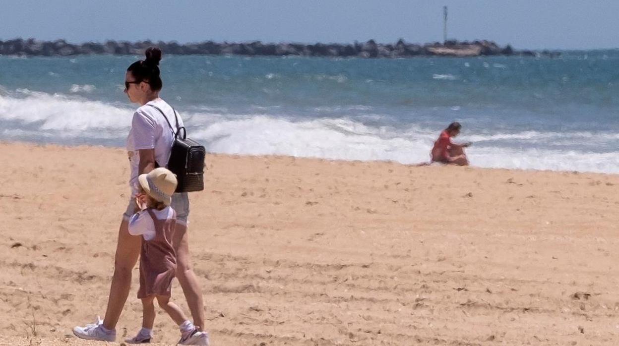 Una madre y su hija pasean por la playa