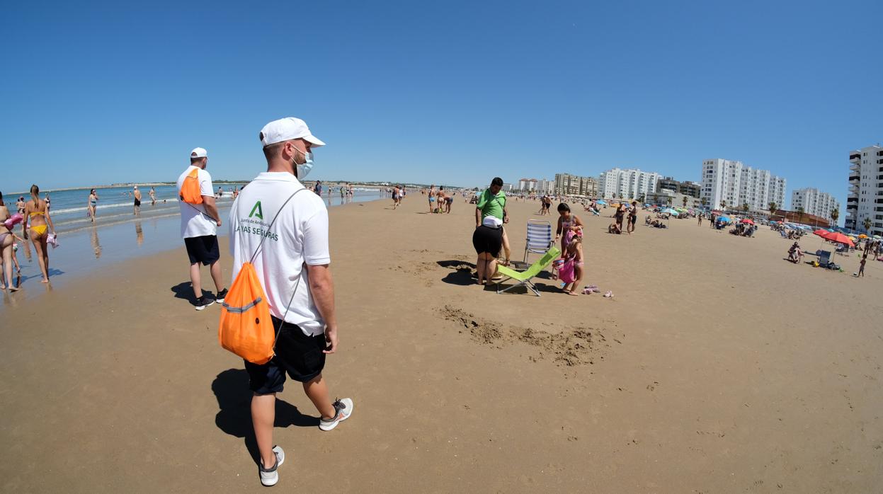 Dos vigilantes supervisan el cumplimiento de las normas anticovid este domingo en la playa de Valdelagrana, en Cádiz