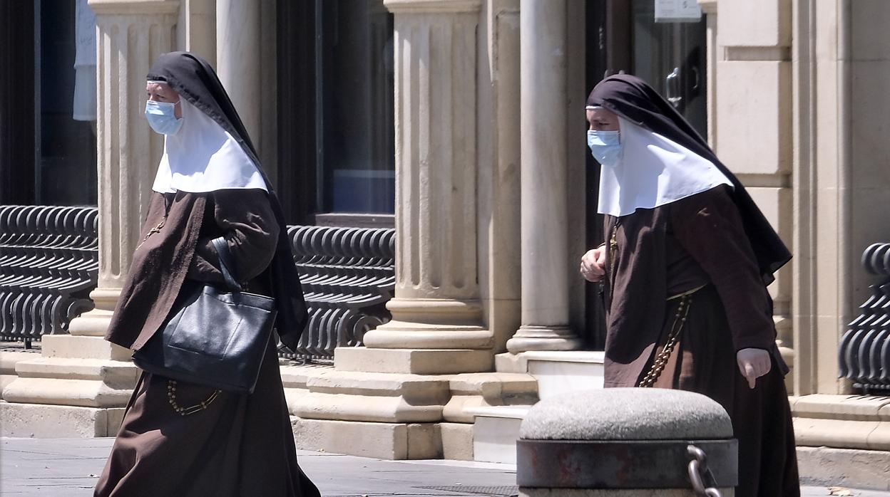 Dos religiosas caminan por el Casco Antiguo sevillano con sendas mascarillas