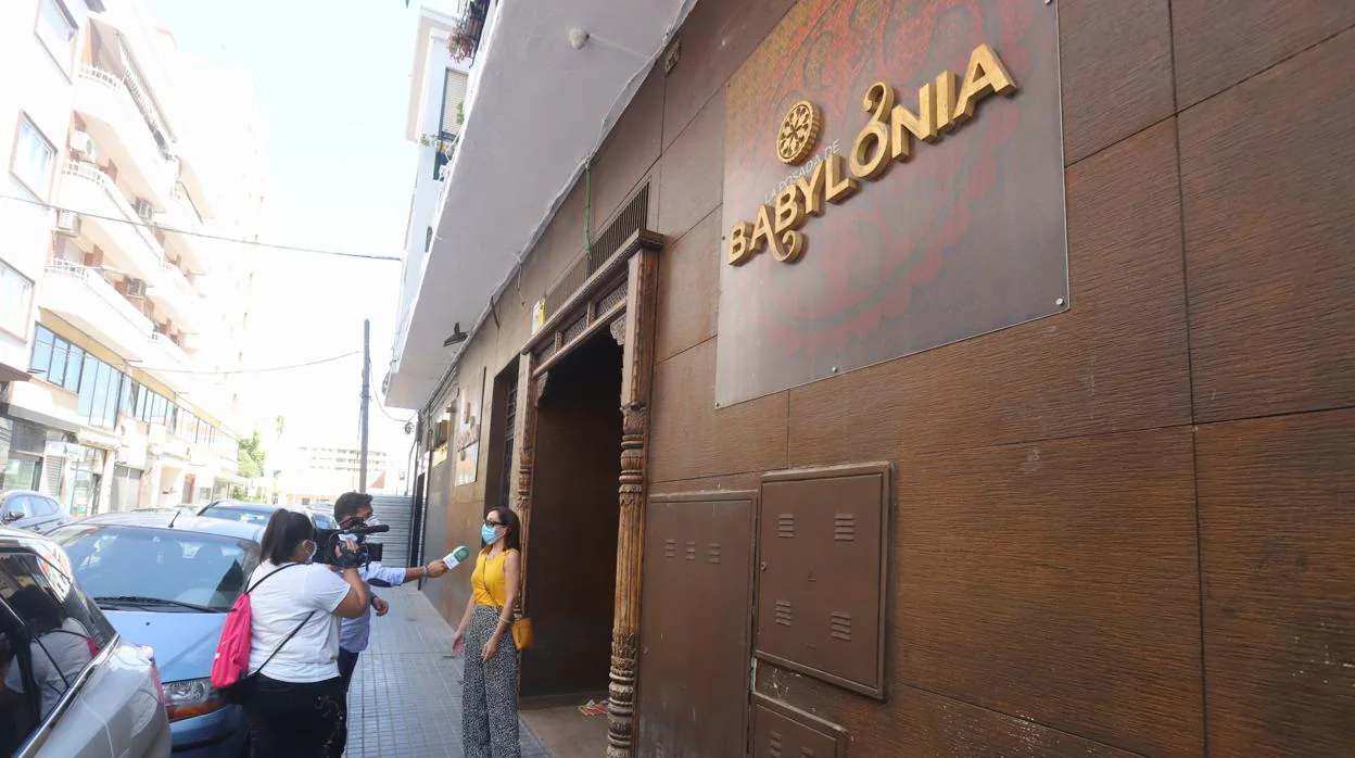 Un reportero entrevista a una mujer en la puerta del a discoteca Babylonia de Córdoba