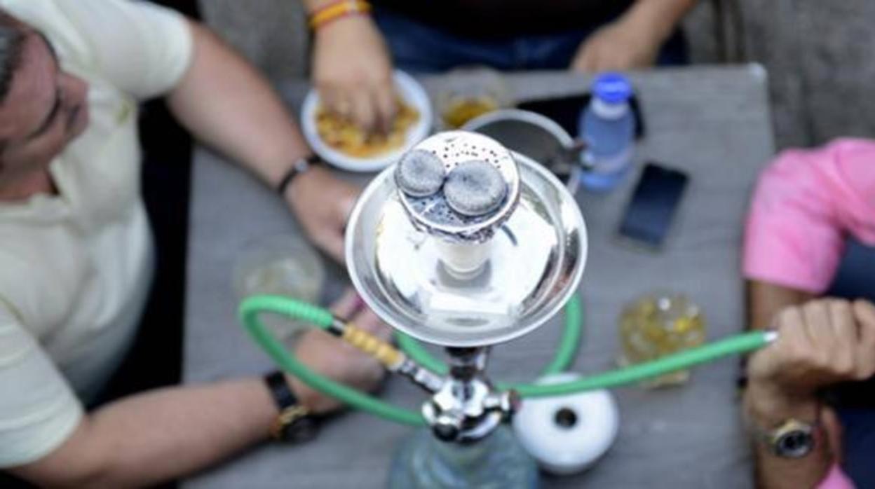 Unos jóvenes fumando en una cachimba
