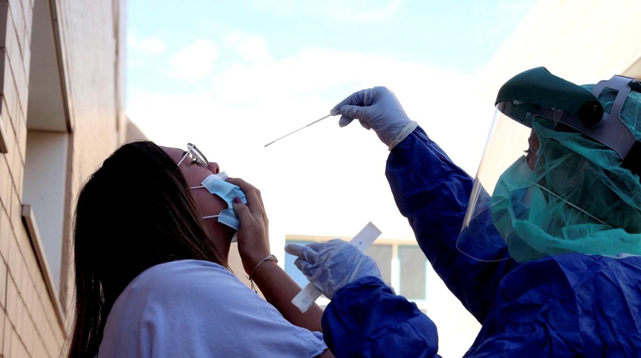 Un sanitario practica una PCR a una joven