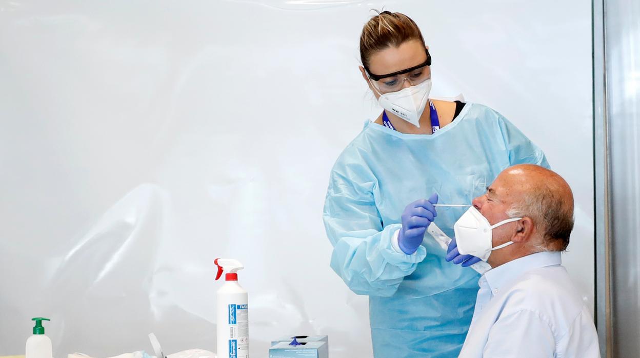 Una enfermera realiza una toma de muestra a un paciente