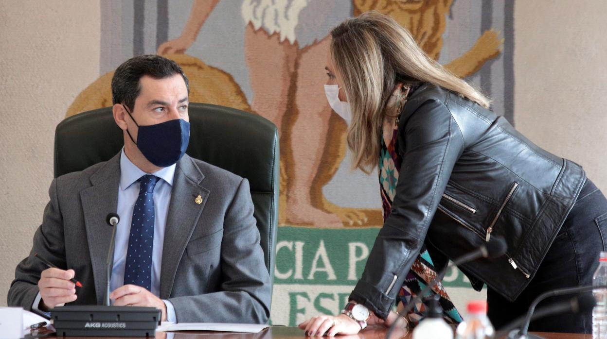 El presidente de la Junta de Andalucía, Juanma Moreno, charla con la consejera de Fomento , Marifrán Carazo, este domingo en Granada