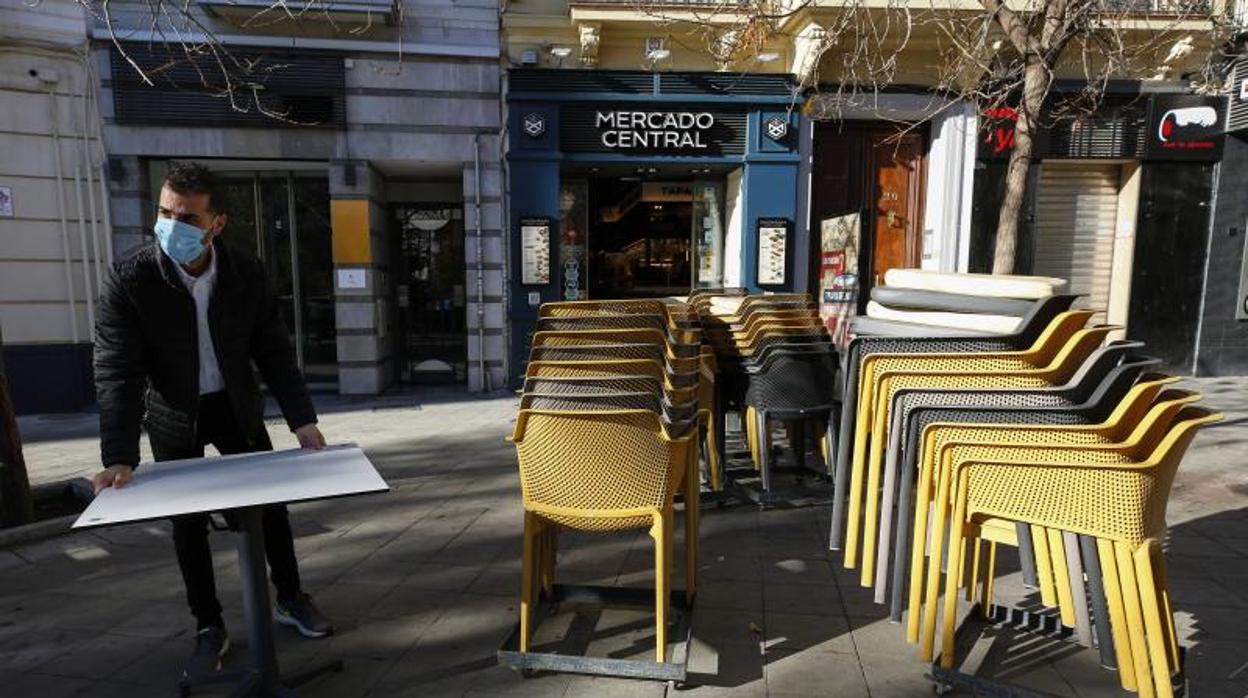 Camareros limpiando y poniendo las mesas en las terrazas de los bares a primera hora de las mañana en Granada después de aliviar las medidas