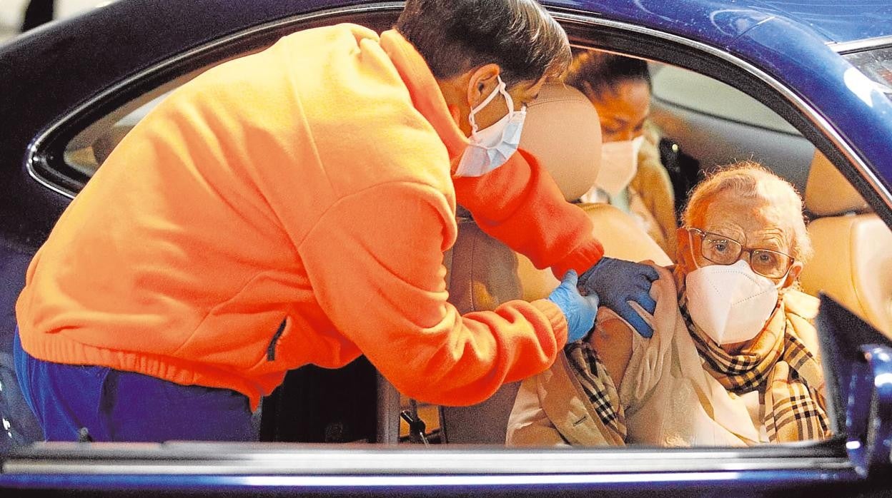 Un señor de más de 80 años recibe su vacuna en el coche
