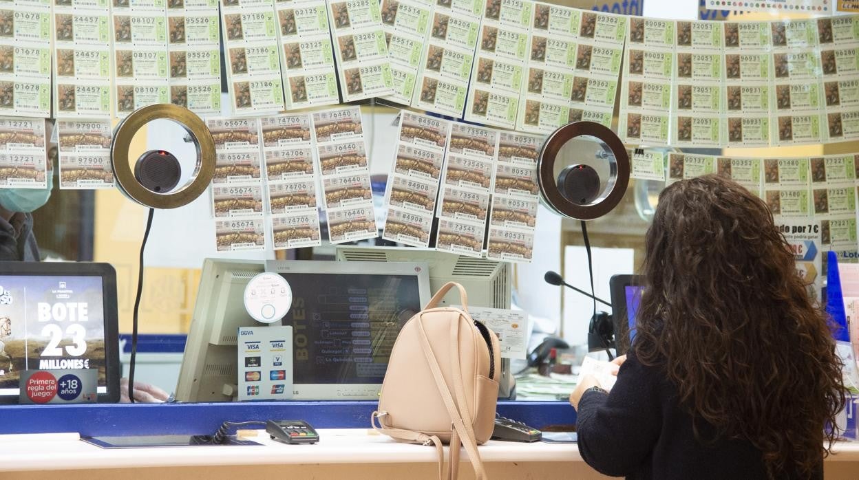 Una mujer compra lotería en una administración