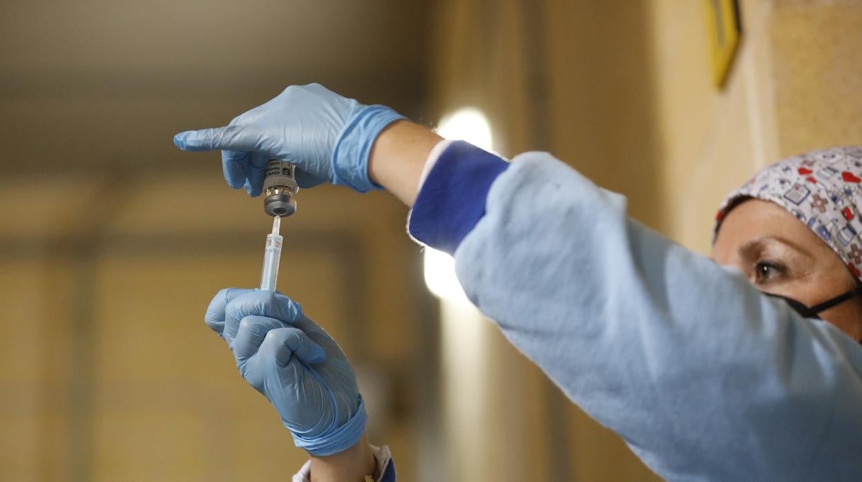 Una profesional sanitaria con una dosis de la vacuna