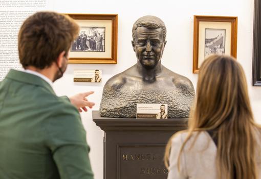 Assitentes a la muestra junto a una escultura de Siurot