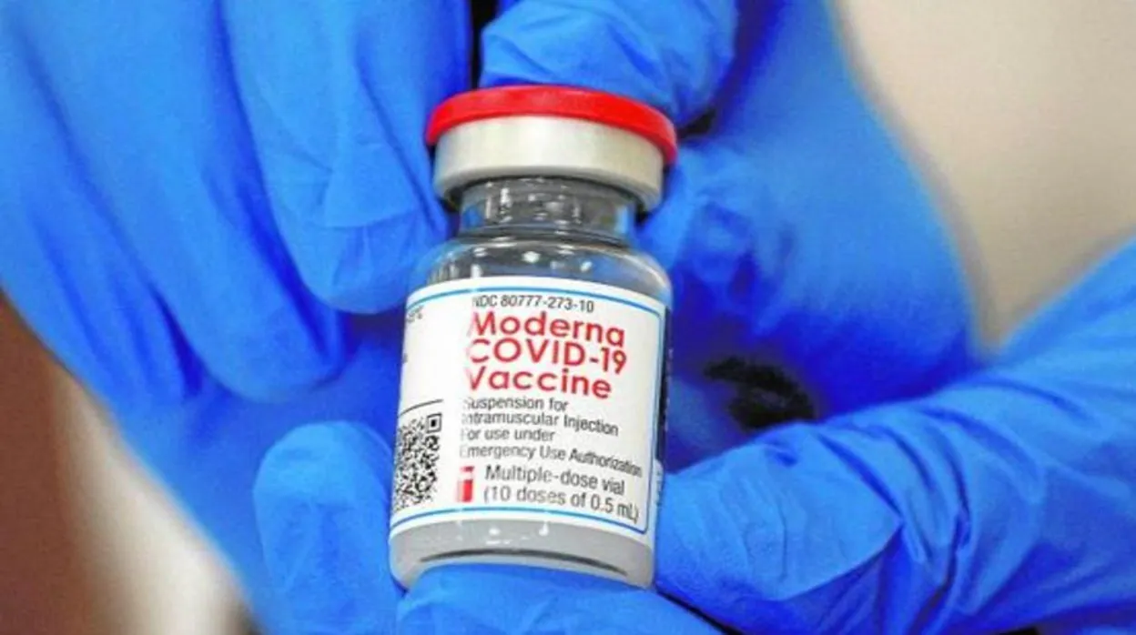 Un empleado de Moderna enseña uno de los viales de la vacuna