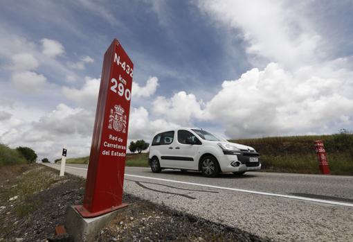 Un coche, ayer pasando delante de un hito señalizador de la N-432
