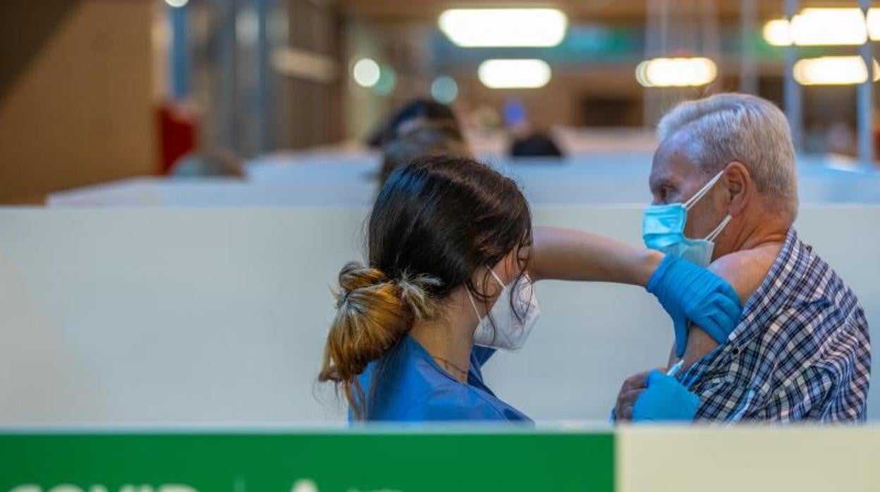 Una persona recibe su primera vacuna contra el Covid en el estadio de la Cartuja en Sevilla