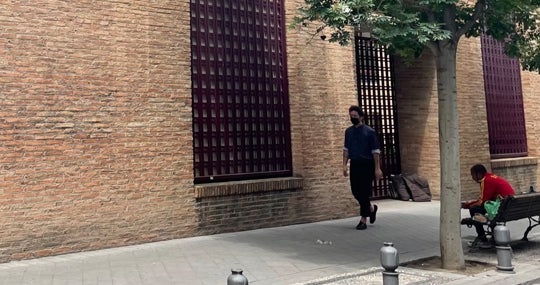 Un hombre come tras recoger su bolsa en el comedor social de San Juan de Dios