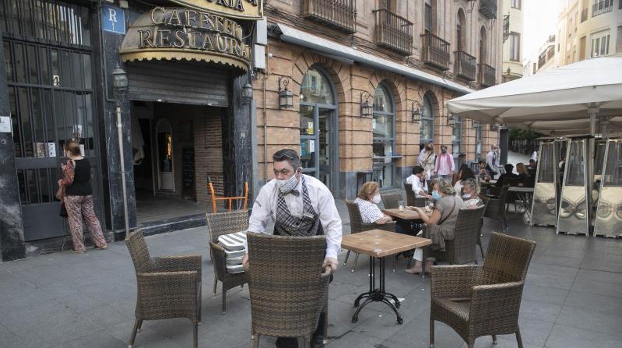 Un camarero prepara un velador en una terraza de Córdoba