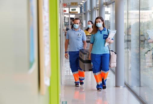 Dos sanitarios portan las dosis en las instalaciones del Distrito para cargarlas en el coche
