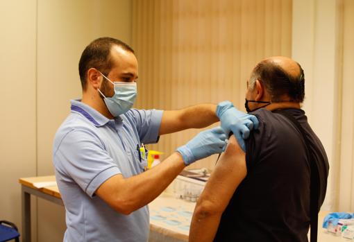 El enfermero José Antonio Agudo le pone un inyectable a un vecino junto a Santuario