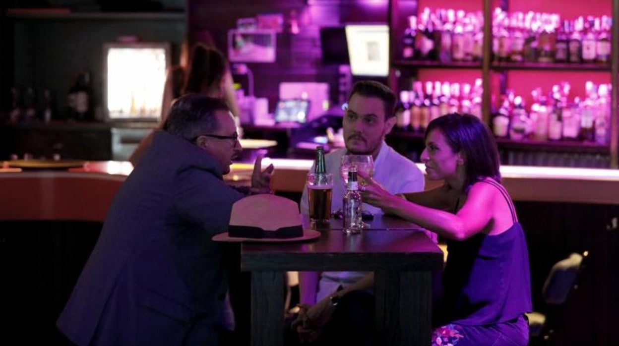Tres personas en una mesa instalada en el interior de un bar de copas para cumplir con las medidas antiCovid