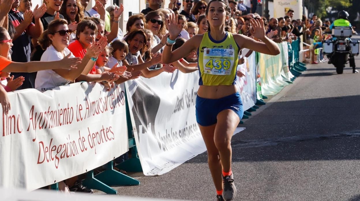 Una de las corredoras llega a la meta en la última edición de la Media Córdoba - Almodóvar