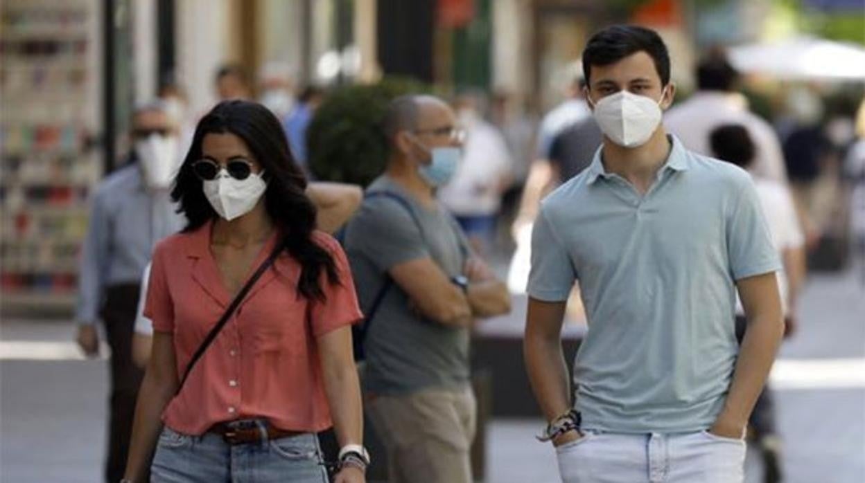 Ciudadanos por la calle con la mascarilla puesta