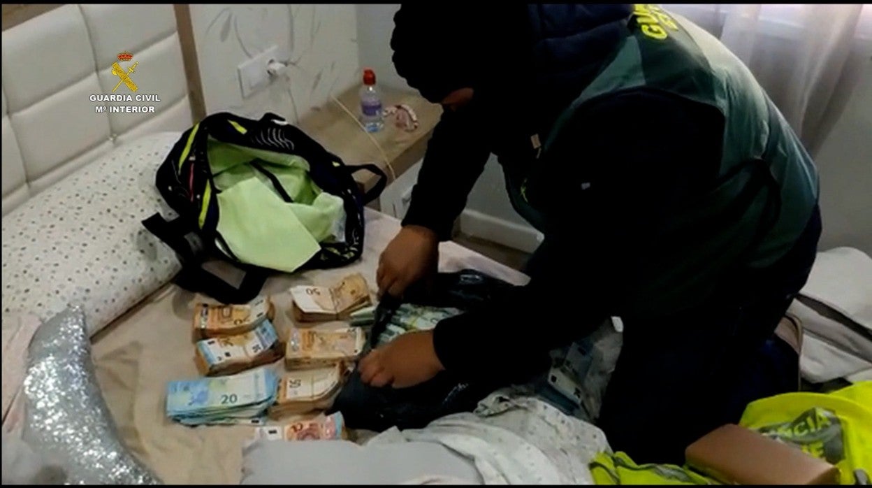 La Guardia Civil sobre el colchón donde estaba el dinero sacando lo que había en la mochila de la niña