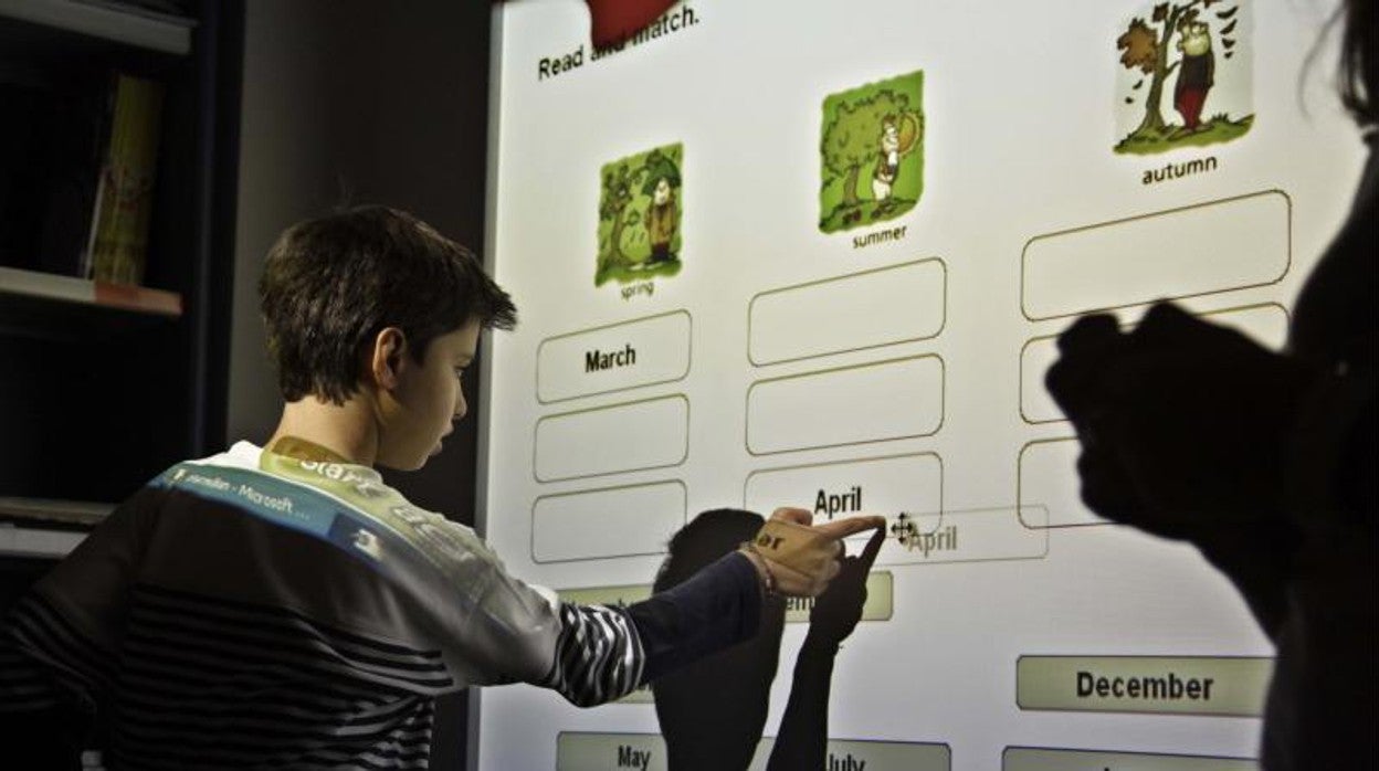 Un alumno usa una pizarra digital en una clase de inglés