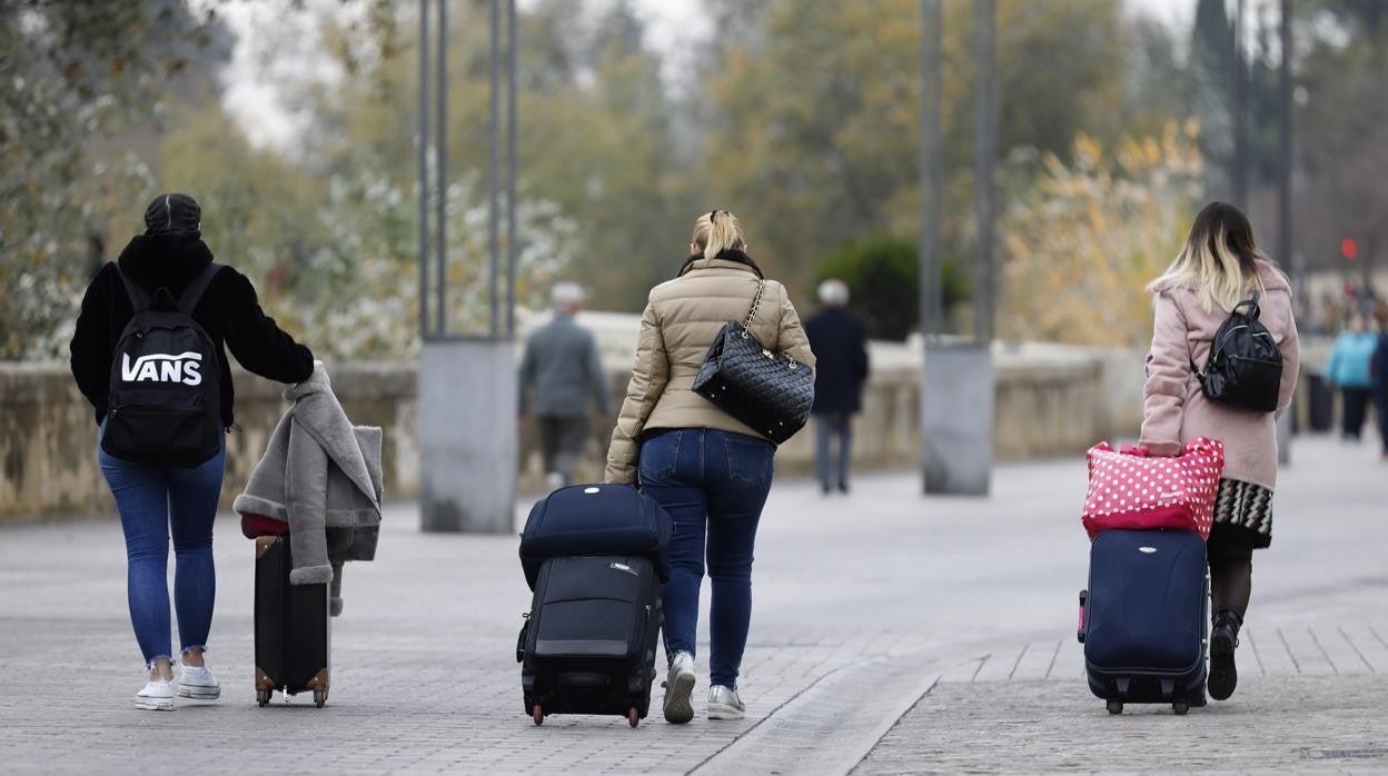 Un grupo de jóvenes turistas llevando sus malestas por la Ribera de Córdoba