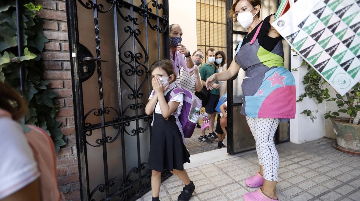 Una escolar entra en su colegio al inicio de curso en septiembre pasado ante un grupo de padres en la puerta