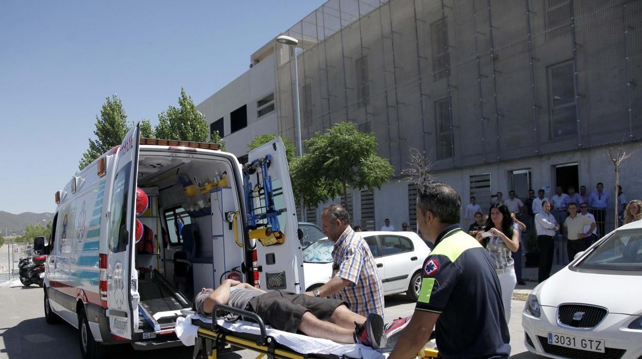 Un profesional sanitario introduce a un paciente en un vehículo medicalizado