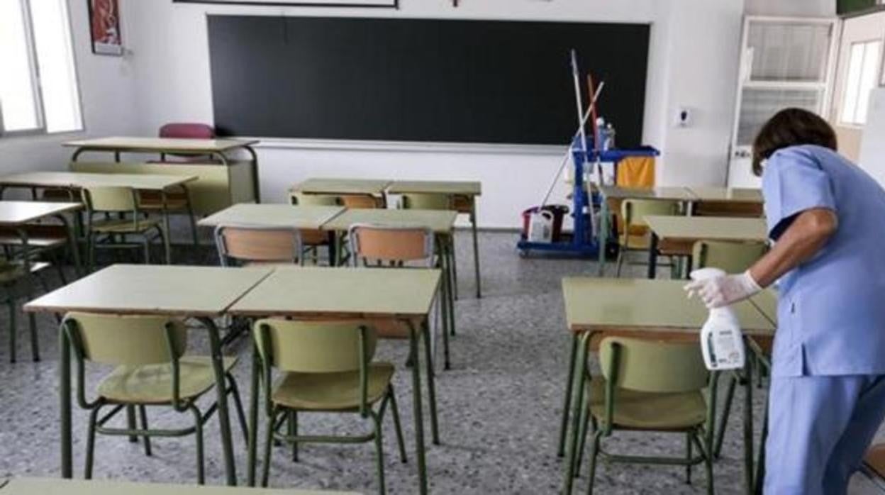 Una limpiadora desinfecta un aula