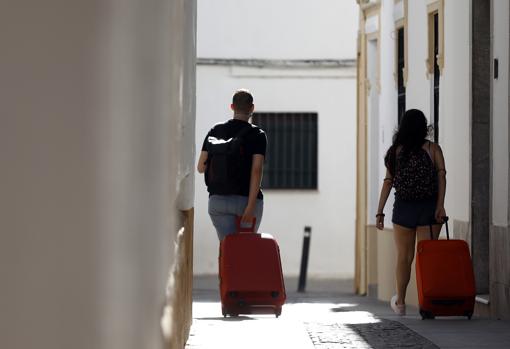 Dos turistas en el Casco llevando sus maletas