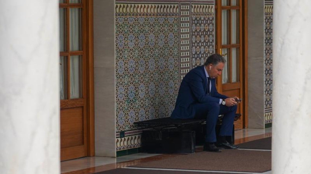 El consejero de la Presidencia, Elías Bendodo, en un banco de los pasillos del Parlamento