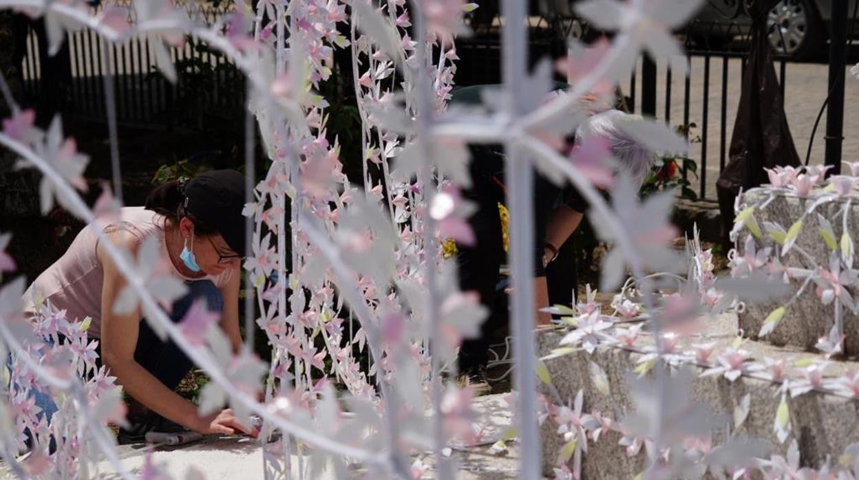 Una mujer retoca una de las Cruces