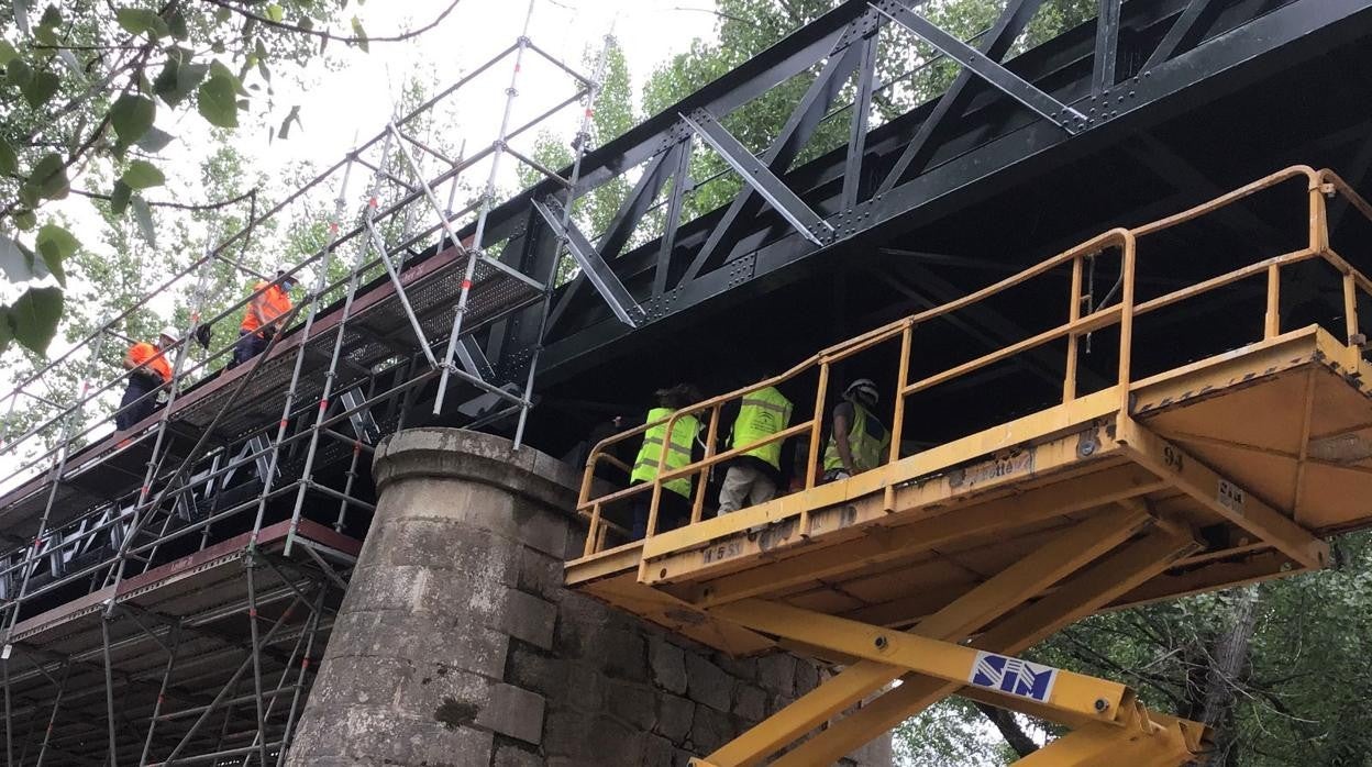 OPerarios arreglan un puente