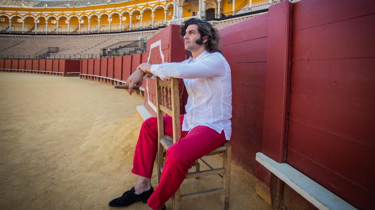 El diestro cigarrero sentado en una silla de enea junto a un burladero de la Maestranza