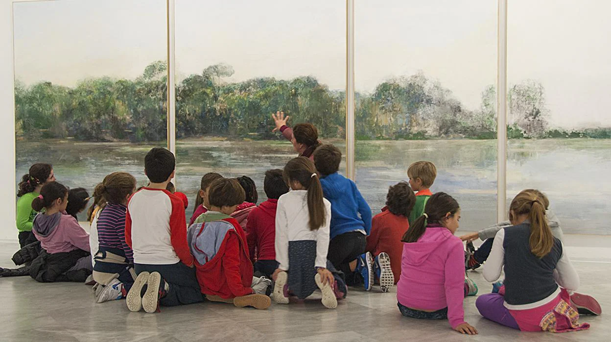 Escolares contemplando en el CAAC un cuadro de la pintora sevillana Carmen Laffón