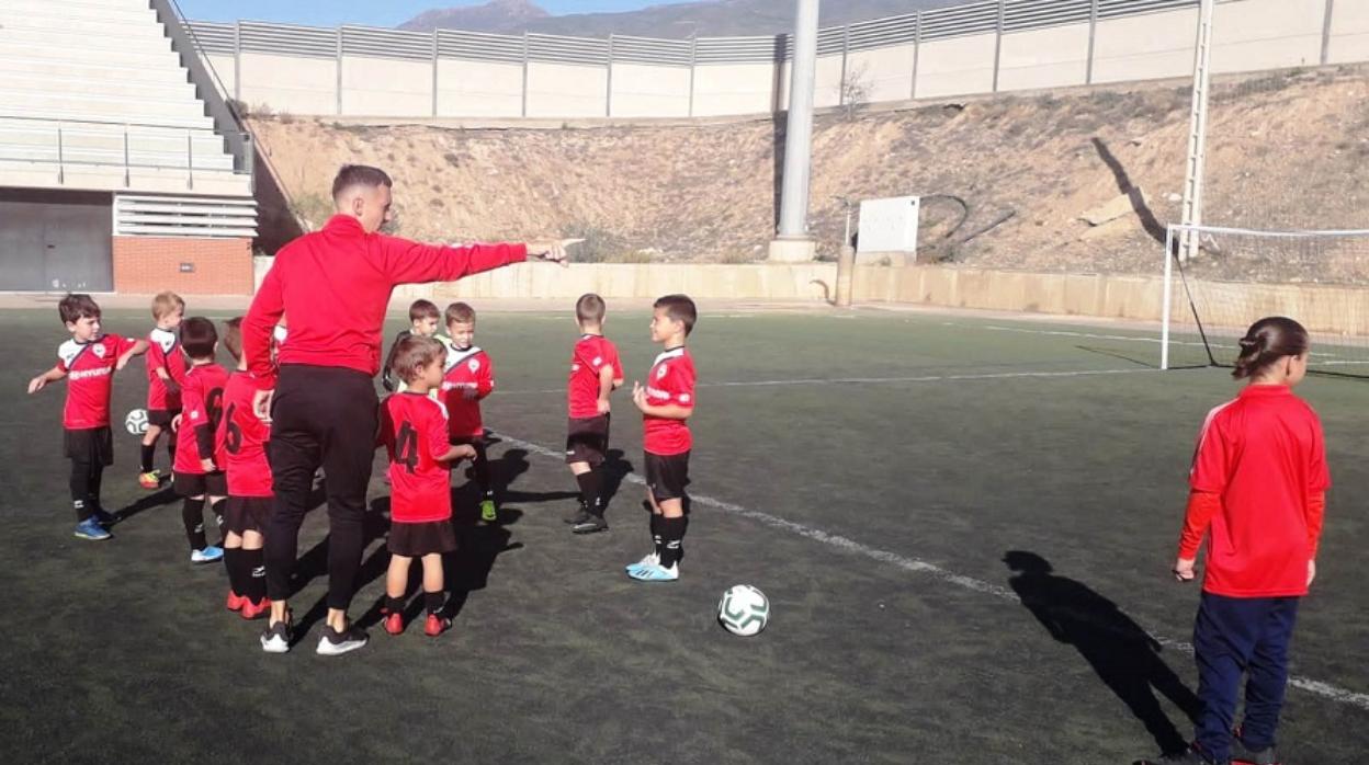 Un entrenador da instrucciones a sus jóvenes futbolistas ante de un partido