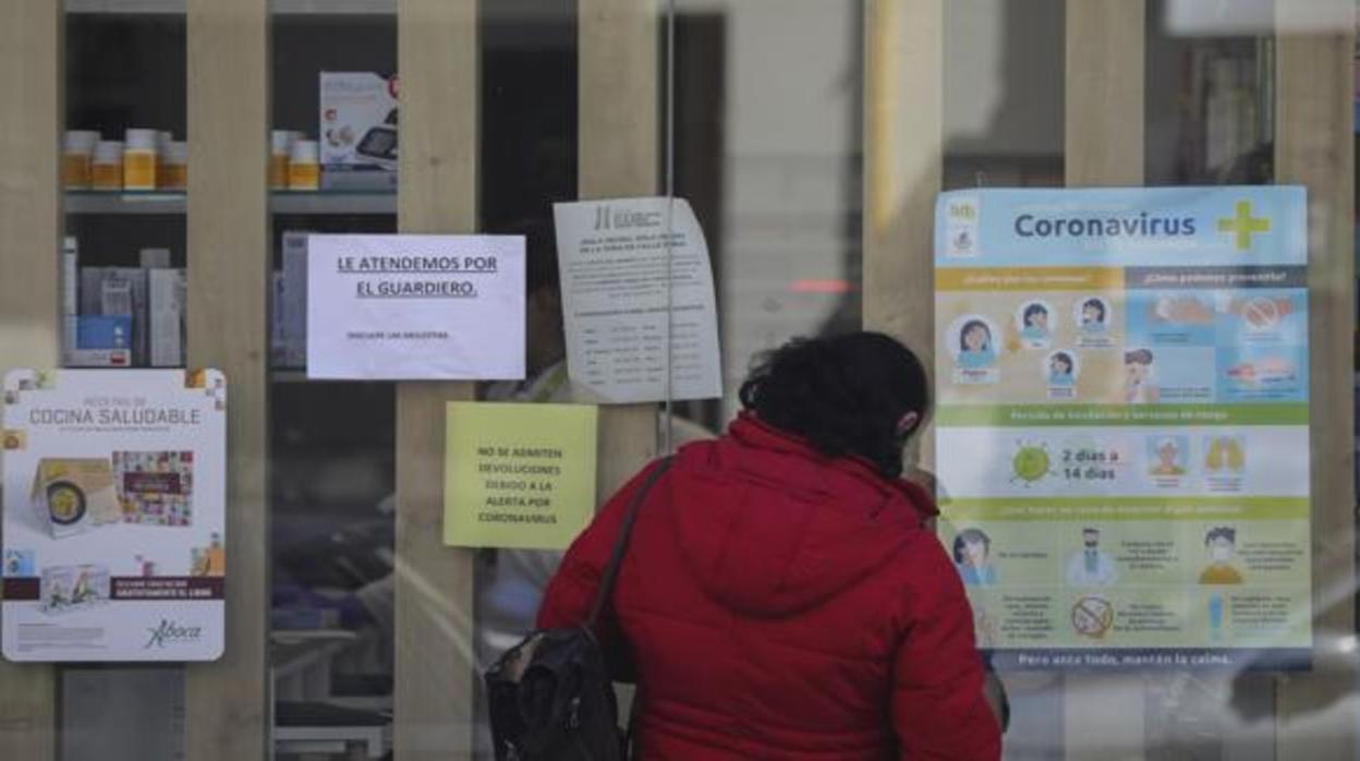 Una mujer contempla carteles sobre el coronavirus