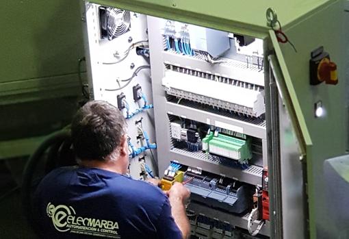Un operario de Elecmarba manipula un equipoPLC que contiene chips