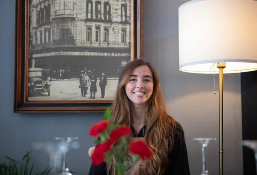 Carlota junto a la fotografía antigua del Gran Café de París de la Campana donde trabajó su bisabuela Pilar