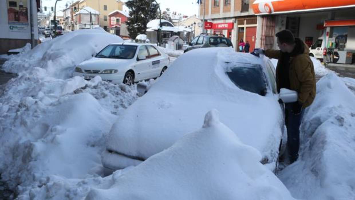 Un conductor quita la nieve de su automóvil tras una gran nevada