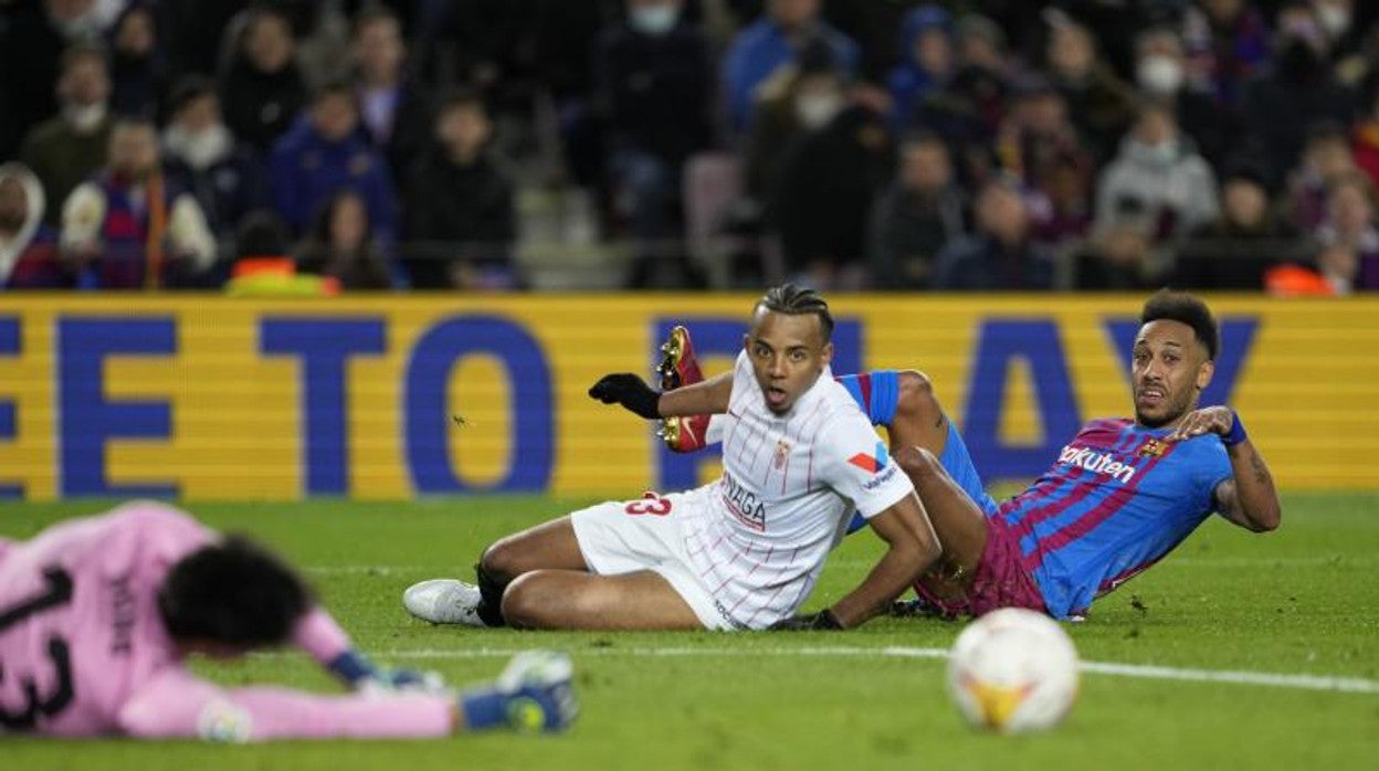 Koundé y Aubameyang observan el balón ante la estirada de Bono